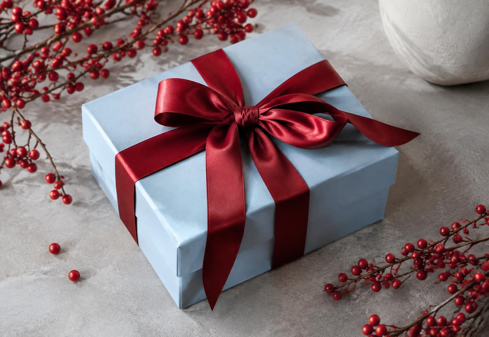 Caja de regalo azul con moño rojo